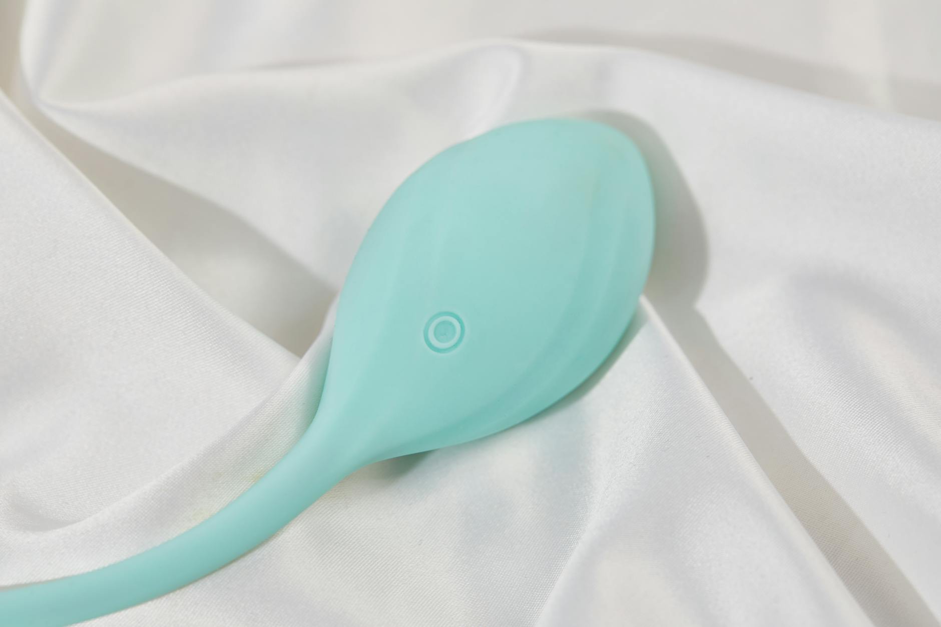 Hand holding a blue silicone vibrator against purple background, representing solo pleasure and self-discovery