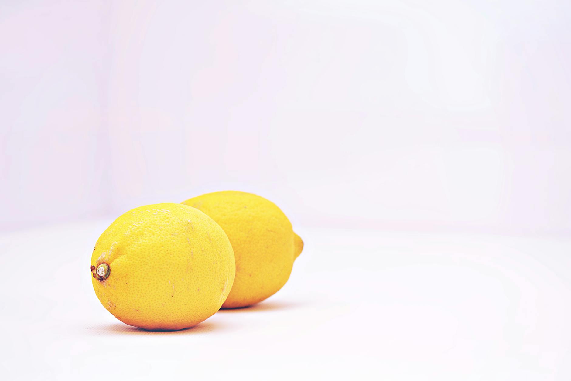 Fresh lemons on white background symbolizing renewal and vitality during bodily transitions