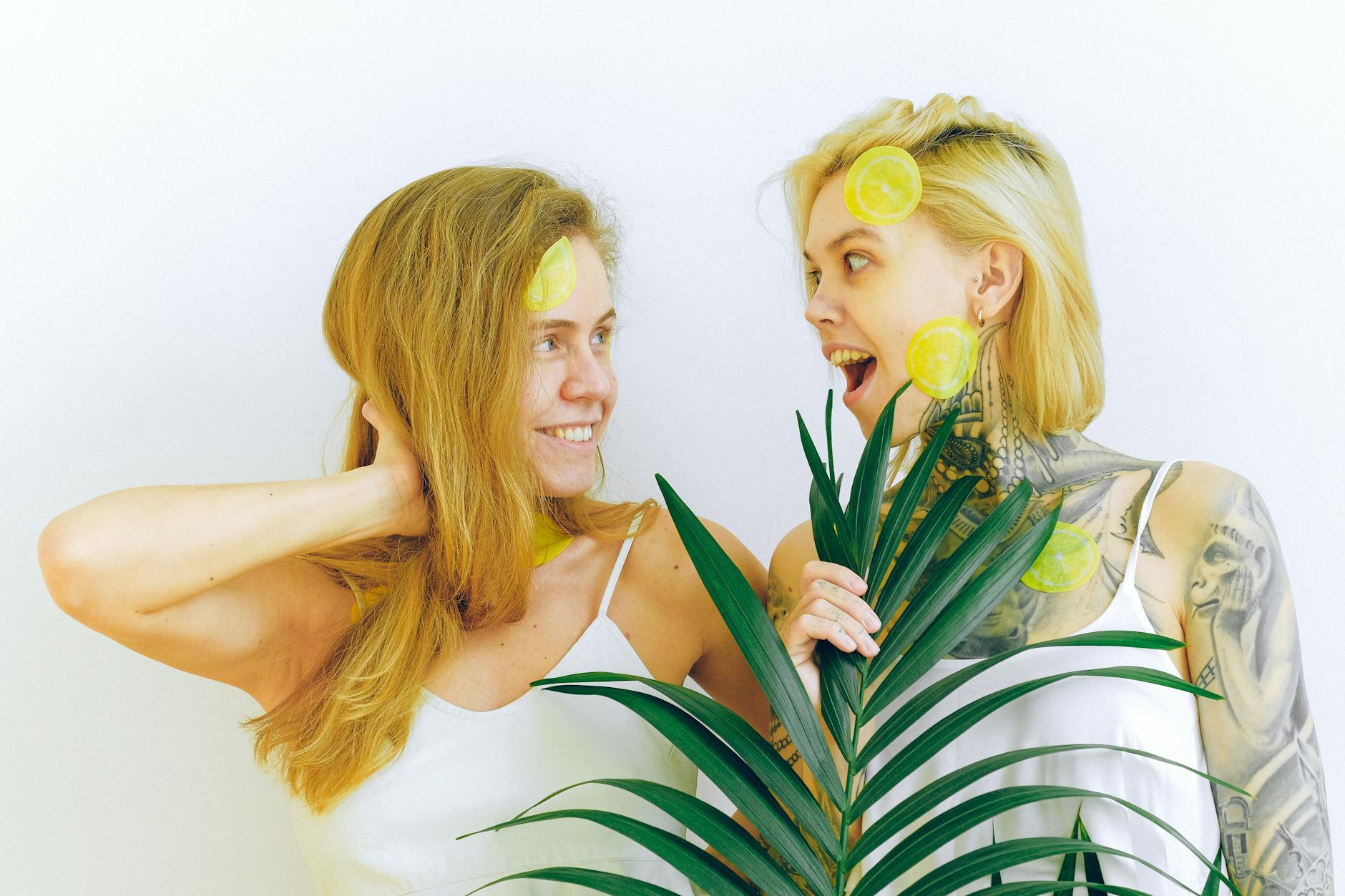 Two women smiling together holding fresh lemons, expressing joy and connection