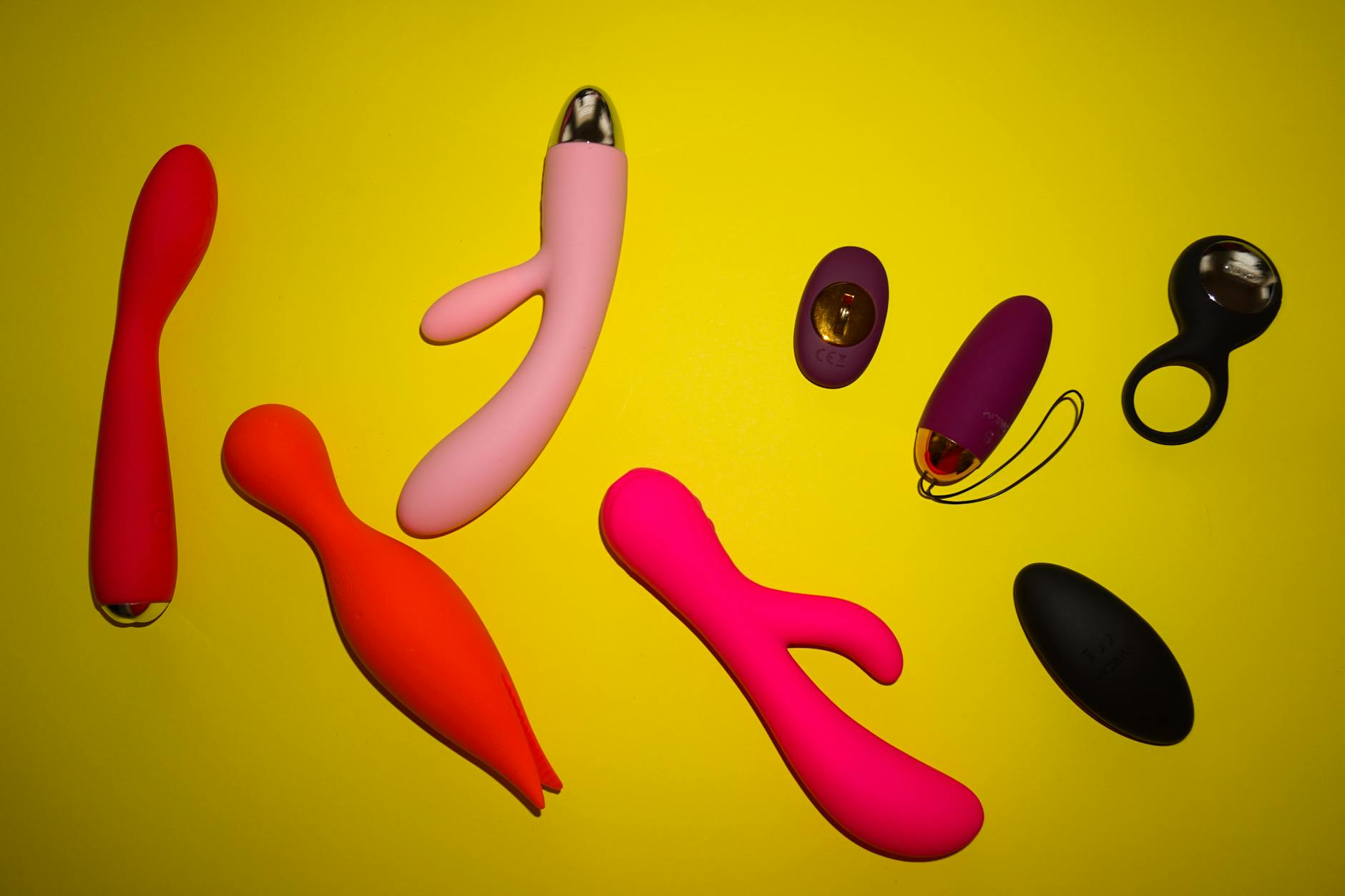 Hand holding a clitoral vibrator against a minimalistic purple backdrop, symbolizing postpartum pleasure and body reclamation